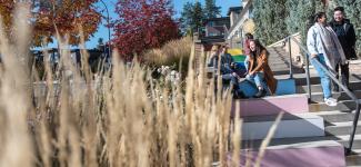 Two students sitting and chatting on a 2SLGBTQ+ painted staircase at UBC Okanagan